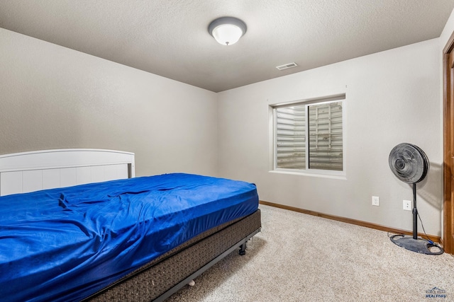 carpeted bedroom featuring a textured ceiling