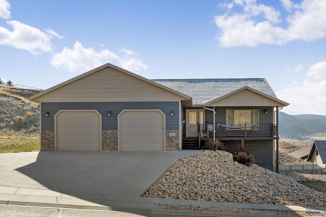 view of front of home featuring a mountain view, a porch, and a garage