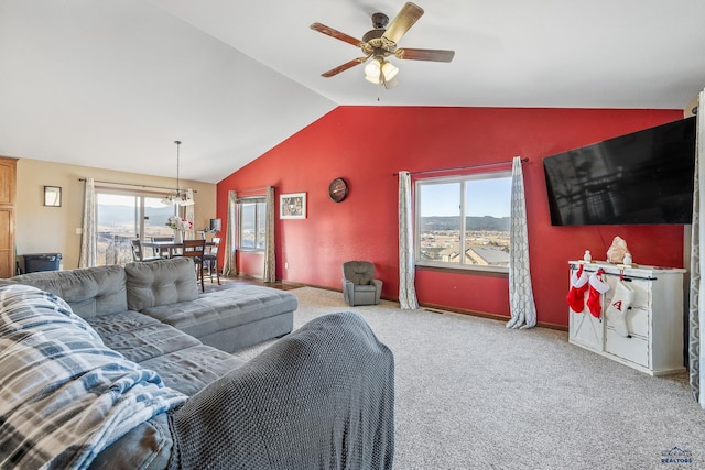 carpeted living room featuring ceiling fan with notable chandelier and vaulted ceiling