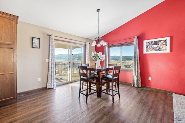 dining room featuring a mountain view, dark hardwood / wood-style floors, a chandelier, and lofted ceiling