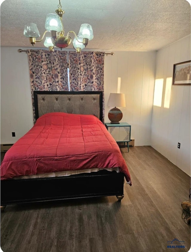 bedroom featuring pool table, wood-type flooring, a textured ceiling, and a baseboard heating unit