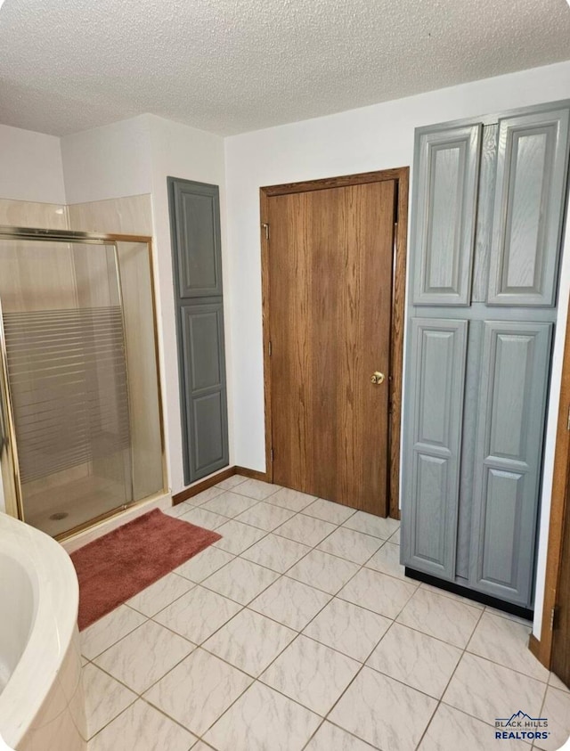 bathroom featuring tile patterned floors, a textured ceiling, and walk in shower