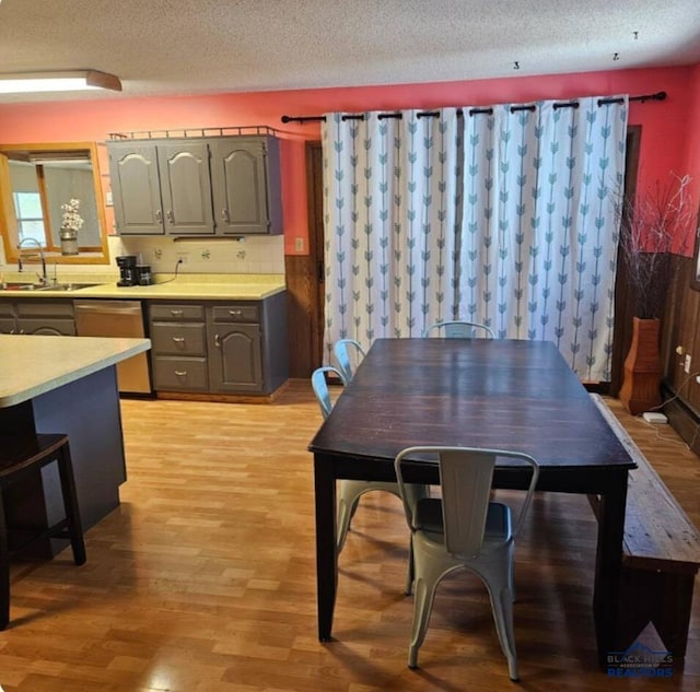 dining room with a textured ceiling, light hardwood / wood-style floors, and sink