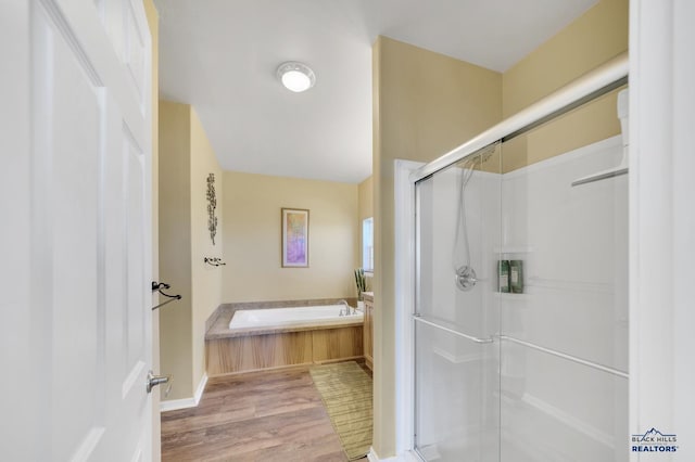 bathroom with hardwood / wood-style flooring and independent shower and bath