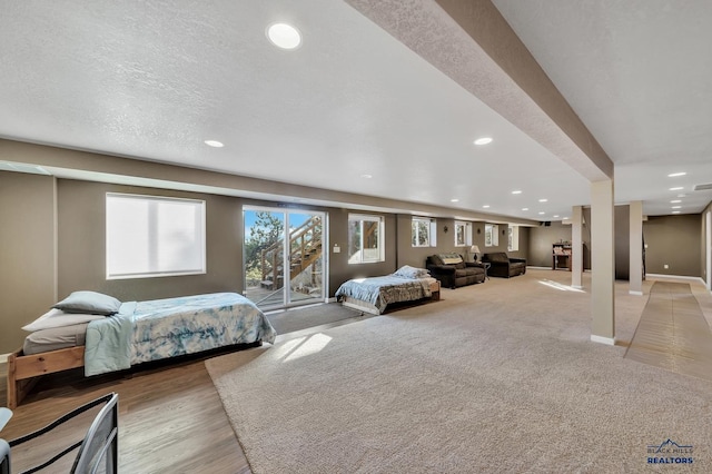 bedroom featuring access to outside, light carpet, and a textured ceiling