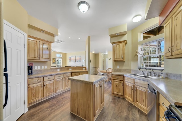 kitchen with sink, a kitchen island, dark wood-type flooring, and appliances with stainless steel finishes