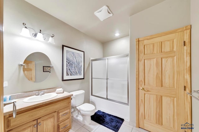 full bathroom with toilet, vanity, tile patterned floors, and bath / shower combo with glass door