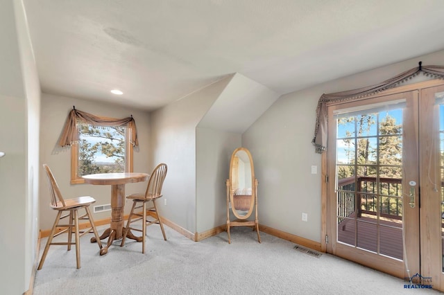 living area featuring light carpet and lofted ceiling