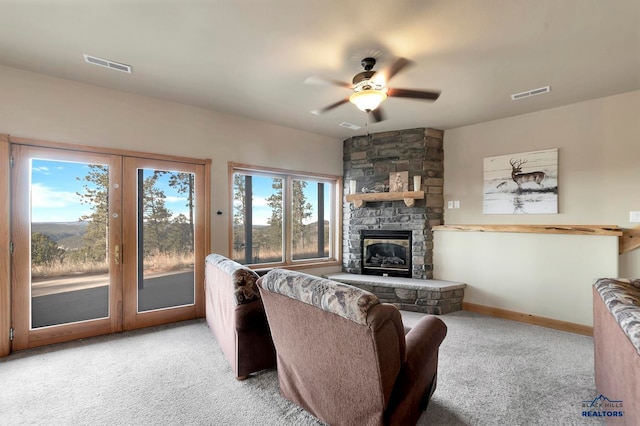 carpeted living room featuring a fireplace and ceiling fan