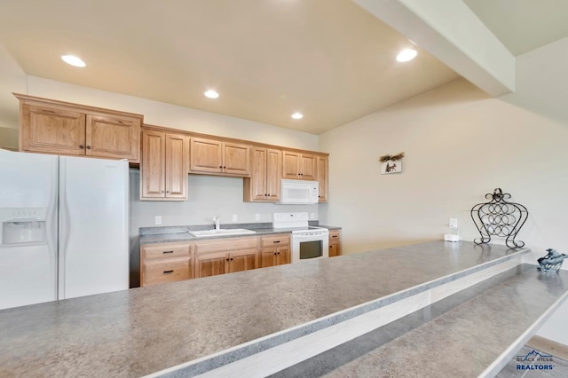 kitchen with kitchen peninsula, white appliances, and sink