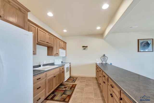 kitchen featuring sink, light tile patterned floors, and white appliances