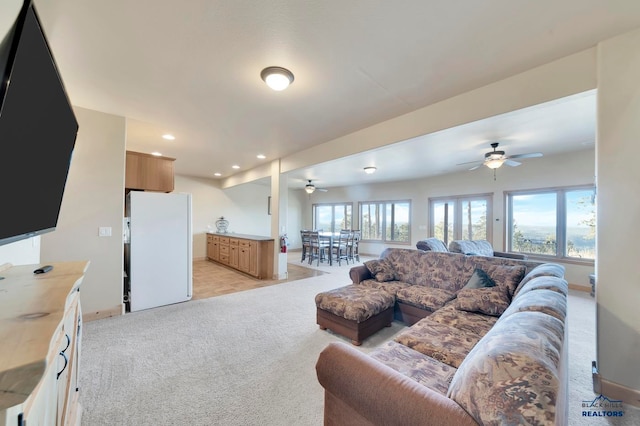 living room with ceiling fan and light colored carpet