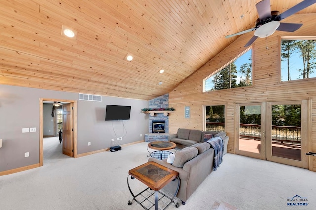 carpeted living room with french doors, wood ceiling, ceiling fan, high vaulted ceiling, and a stone fireplace