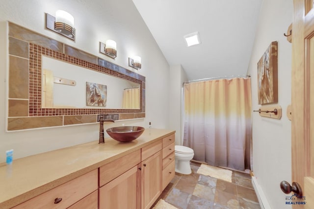 bathroom with vanity, toilet, and lofted ceiling