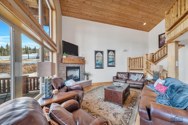 living room with hardwood / wood-style floors, wooden ceiling, high vaulted ceiling, and a stone fireplace