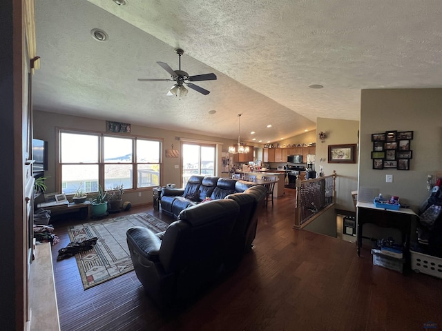 living room featuring ceiling fan with notable chandelier, wood-type flooring, a textured ceiling, and lofted ceiling