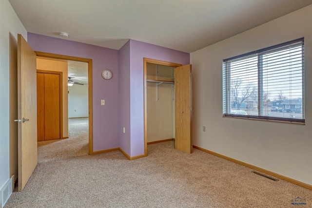 unfurnished bedroom with light carpet and a closet