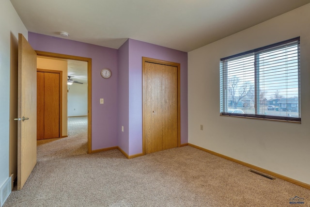 unfurnished bedroom featuring light carpet and a closet