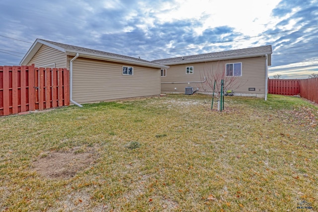 rear view of house with a yard and central AC unit