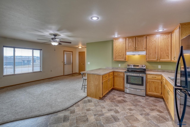 kitchen with ceiling fan, light brown cabinets, kitchen peninsula, light colored carpet, and stainless steel electric range