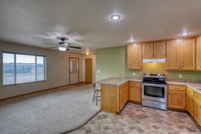 kitchen featuring stainless steel electric range, light carpet, a kitchen breakfast bar, ceiling fan, and kitchen peninsula