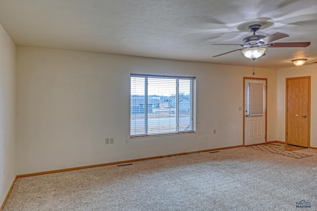 unfurnished room with carpet flooring, ceiling fan, and a textured ceiling