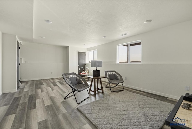 sitting room with a textured ceiling and hardwood / wood-style flooring