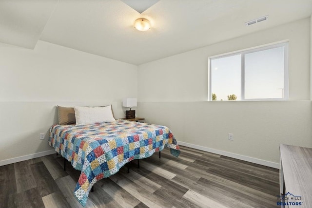 bedroom with dark hardwood / wood-style floors