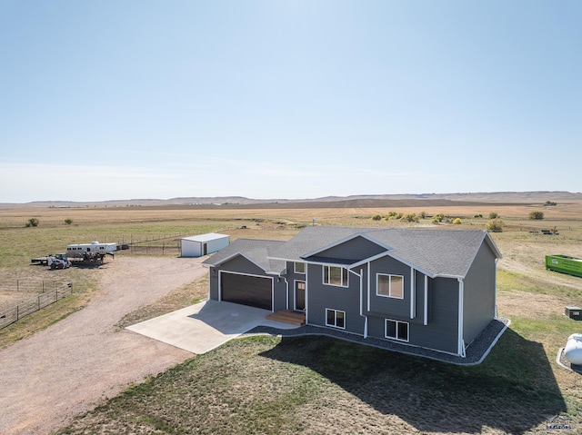 view of front of house with a mountain view, a rural view, and a garage