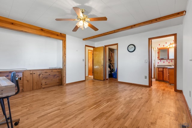 bedroom with a spacious closet, ceiling fan, light hardwood / wood-style flooring, beamed ceiling, and a closet