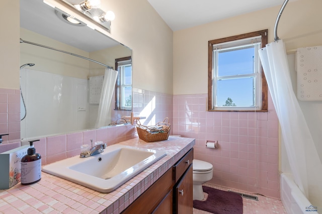 full bathroom with shower / bath combo, vanity, tile walls, and toilet