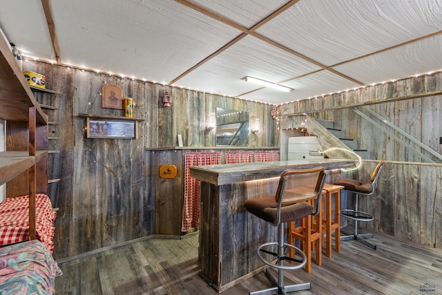 bar with wood walls and dark hardwood / wood-style floors