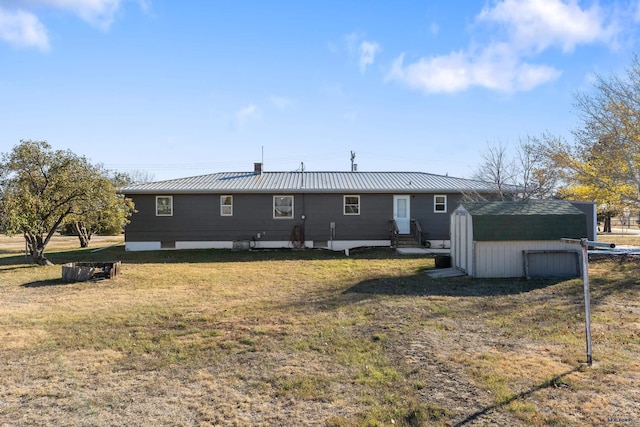 back of house featuring a storage shed and a yard