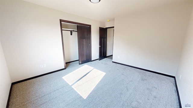 unfurnished bedroom with light colored carpet and a closet