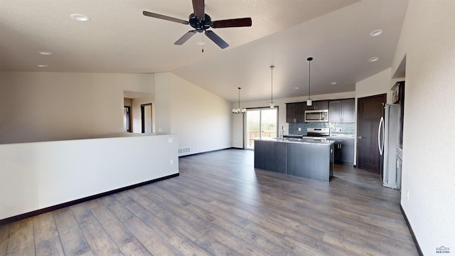 kitchen featuring pendant lighting, a kitchen island with sink, stainless steel appliances, dark hardwood / wood-style flooring, and vaulted ceiling