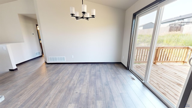 unfurnished dining area with an inviting chandelier and dark hardwood / wood-style floors