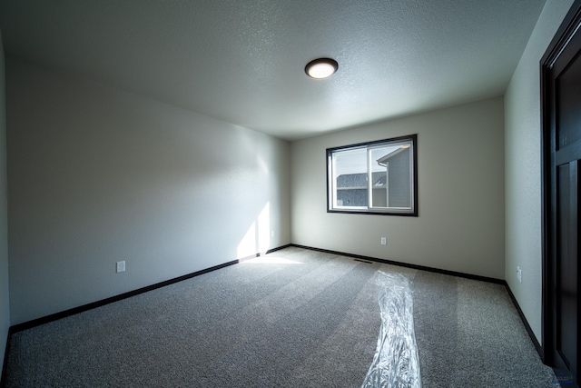 spare room with carpet floors and a textured ceiling