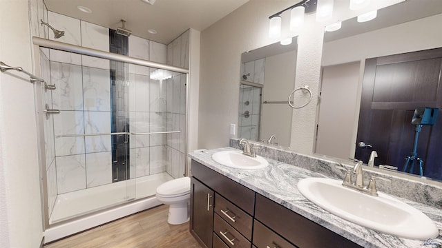 bathroom featuring walk in shower, wood-type flooring, toilet, and vanity