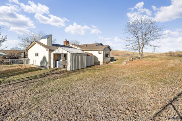 back of house featuring a rural view and a yard