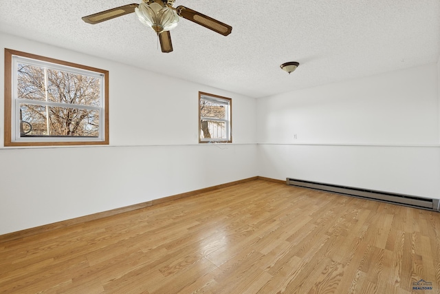 unfurnished room with a textured ceiling, plenty of natural light, light hardwood / wood-style floors, and baseboard heating