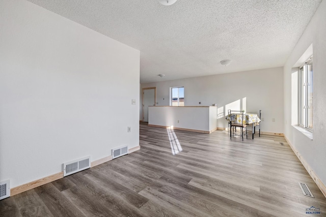 unfurnished living room featuring hardwood / wood-style floors and a textured ceiling