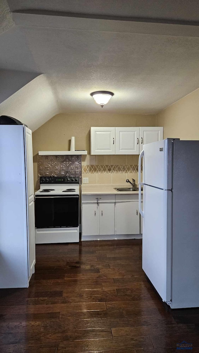 kitchen with white appliances, backsplash, sink, dark hardwood / wood-style flooring, and white cabinetry