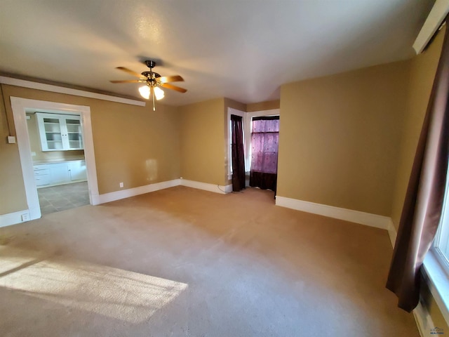 spare room with ceiling fan and light carpet