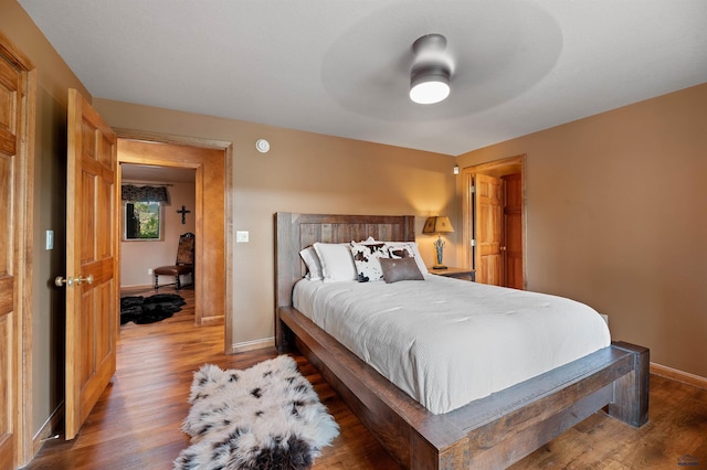 bedroom with ceiling fan and dark wood-type flooring