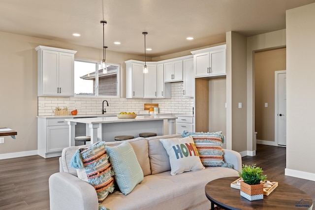 kitchen featuring decorative light fixtures, a kitchen island, dark hardwood / wood-style flooring, and white cabinetry