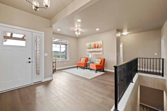 foyer with wood-type flooring and an inviting chandelier