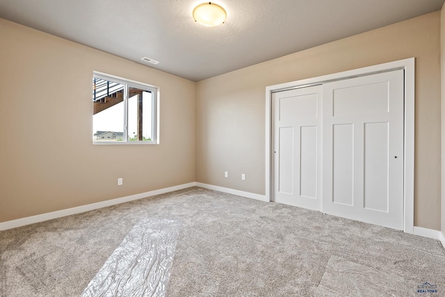 unfurnished bedroom featuring carpet floors and a closet