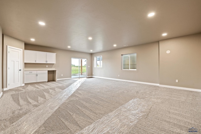 unfurnished living room featuring light colored carpet