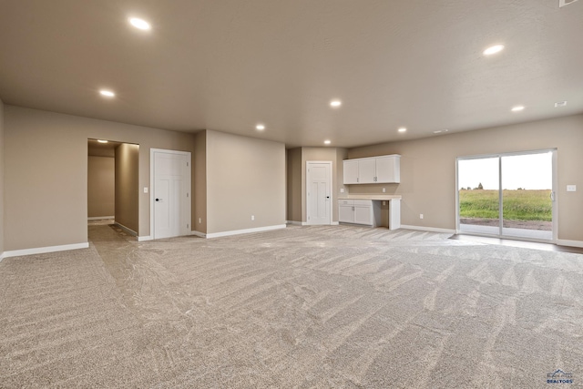 unfurnished living room with light colored carpet