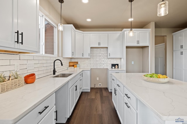 kitchen with pendant lighting, white cabinets, and sink